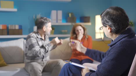 un psiquiatra escuchando a una pareja de mediana edad.