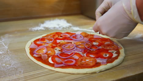 pizza preparation.hands putting slices of onions on pizza dough on table. process of making pizza. chef prepares filling for delicious pizza.
