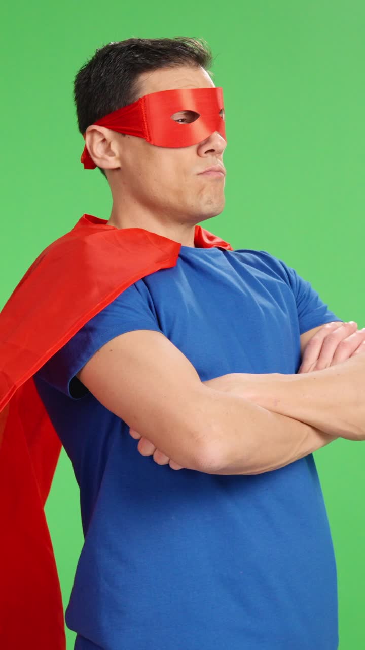 Superhero waiting with arms crossed on green screen