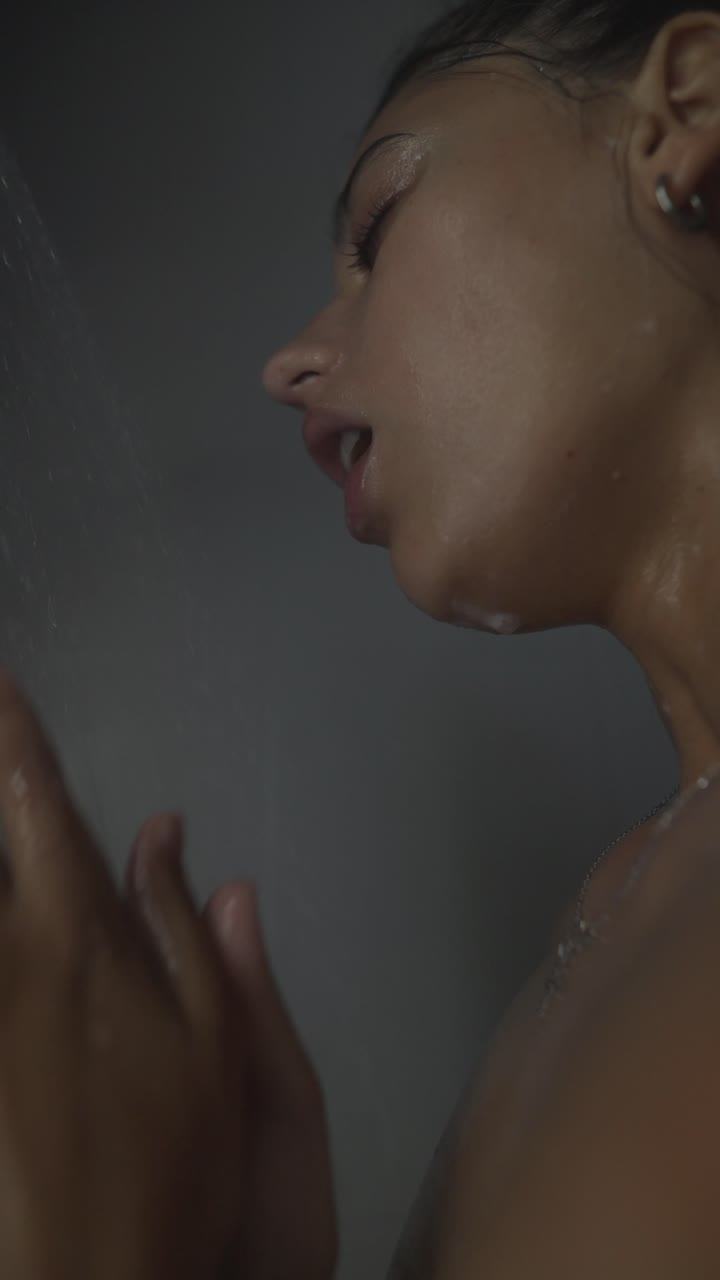 Woman washing her face in the shower