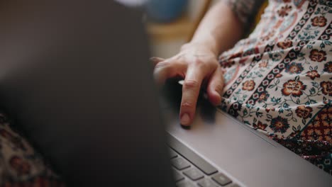 woman's hands scrolling on a laptop