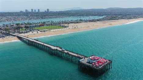 Vista-Aérea-Giratoria-Del-Muelle-Balboa-Y-Rubies-Diner-En-Newport-Beach,-California