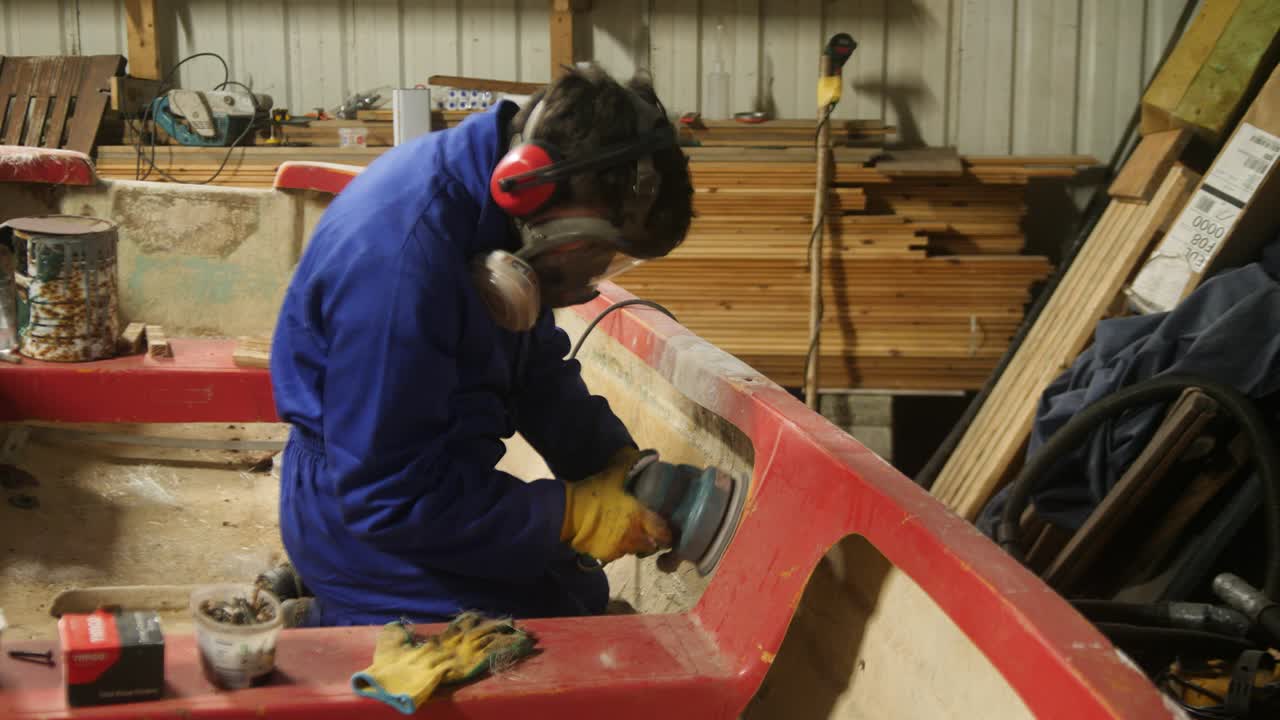 Sanding fiberglass gunwale repair on small fishing boat