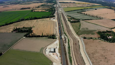 Sobrecarga-Aérea-De-Un-Tren-En-Francia-Mientras-Viaja-Por-El-Sitio-De-Construcción-Y-Luego-En-La-Distancia