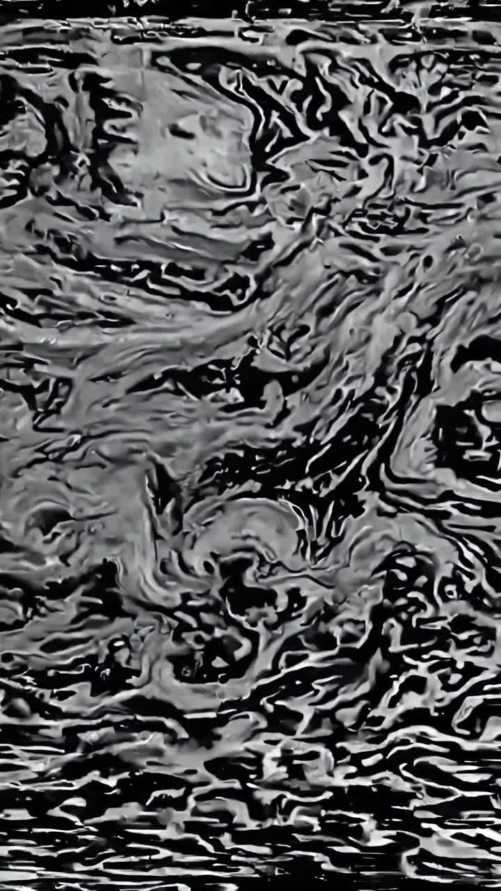 Abstract black and white pattern resembling static, captured from a top-down angle, evoking a retro