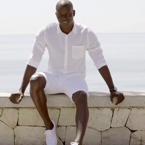 seated male model wearing shorts and dress shirt