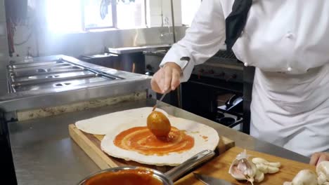 mid-section of female chef preparing pizza