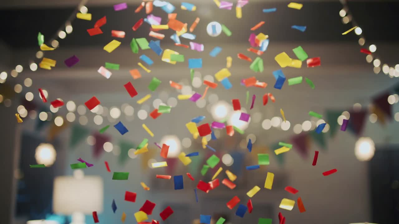 Coriandoli che cadono nel soggiorno per una festa, con lucine decorative e festoni.