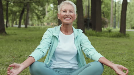 una mujer mayor meditando en el parque.