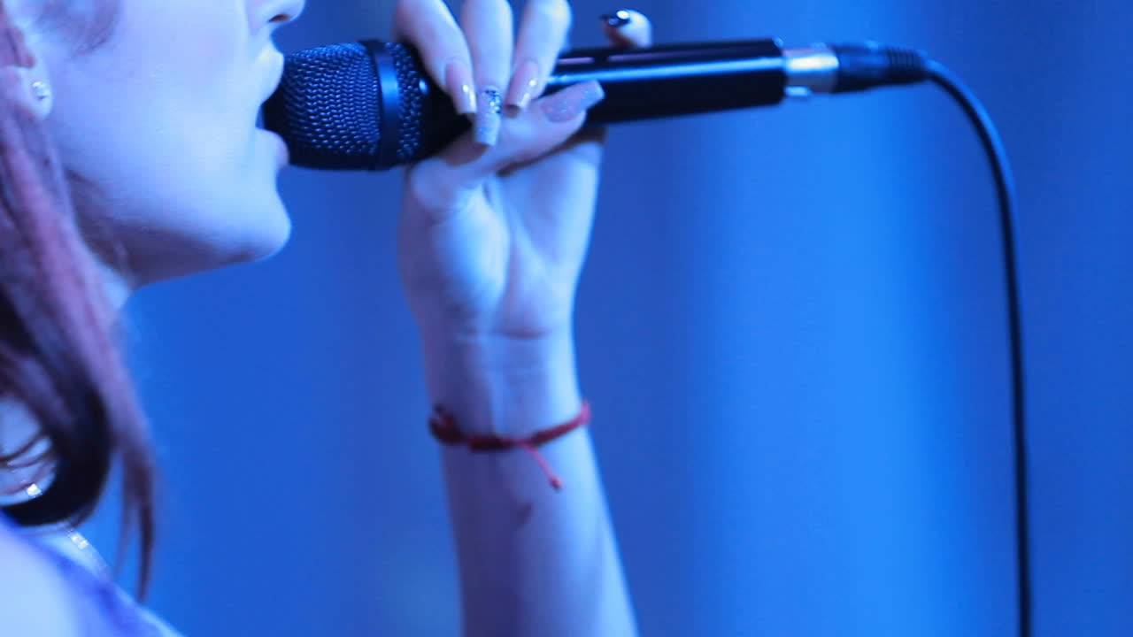 Female vocalist singing in dark stage during the concert