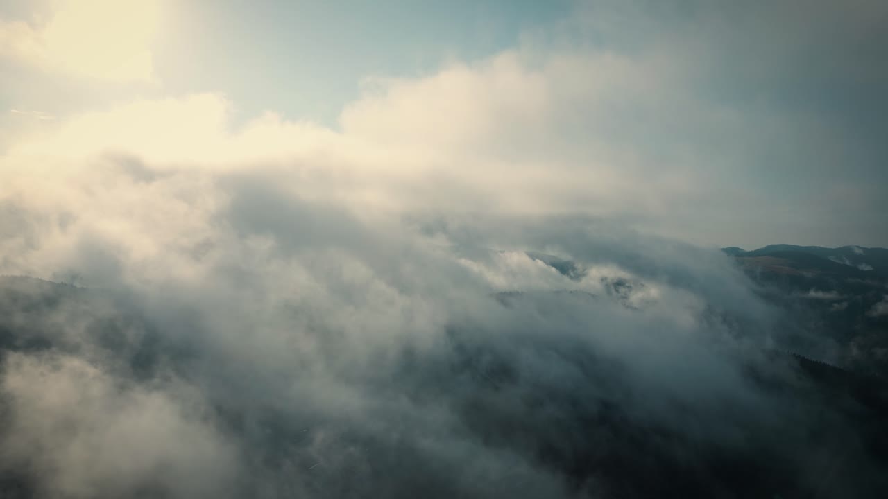 Aerial flying over mountains and through clouds. Skyscape