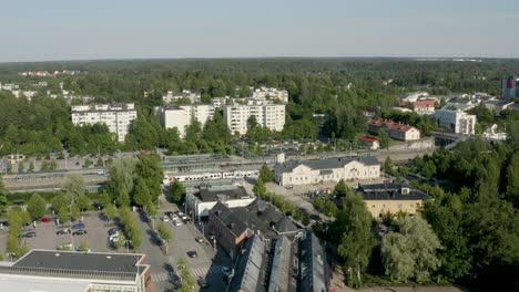 panorámica aérea lenta del tren que sale de la estación en finlandia, cerca de helsinki.