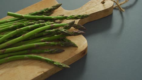 Video-of-asparagus-on-wooden-chopping-board-over-grey-background