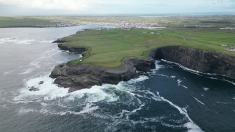 Acantilados-De-Kilkee-En-Irlanda-Con-Olas-Rompientes-Y-Exuberantes-Paisajes-Verdes,-Vista-Aérea