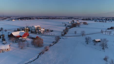 aerial view of early morning sunrise after a snow fall in amish countryside as senn by s drone