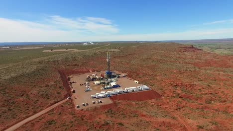 Una-Plataforma-De-Perforación-En-Un-Vasto-Y-árido-Paisaje-Durante-El-Día,-Equipos-Industriales-En-Funcionamiento,-Vista-Aérea