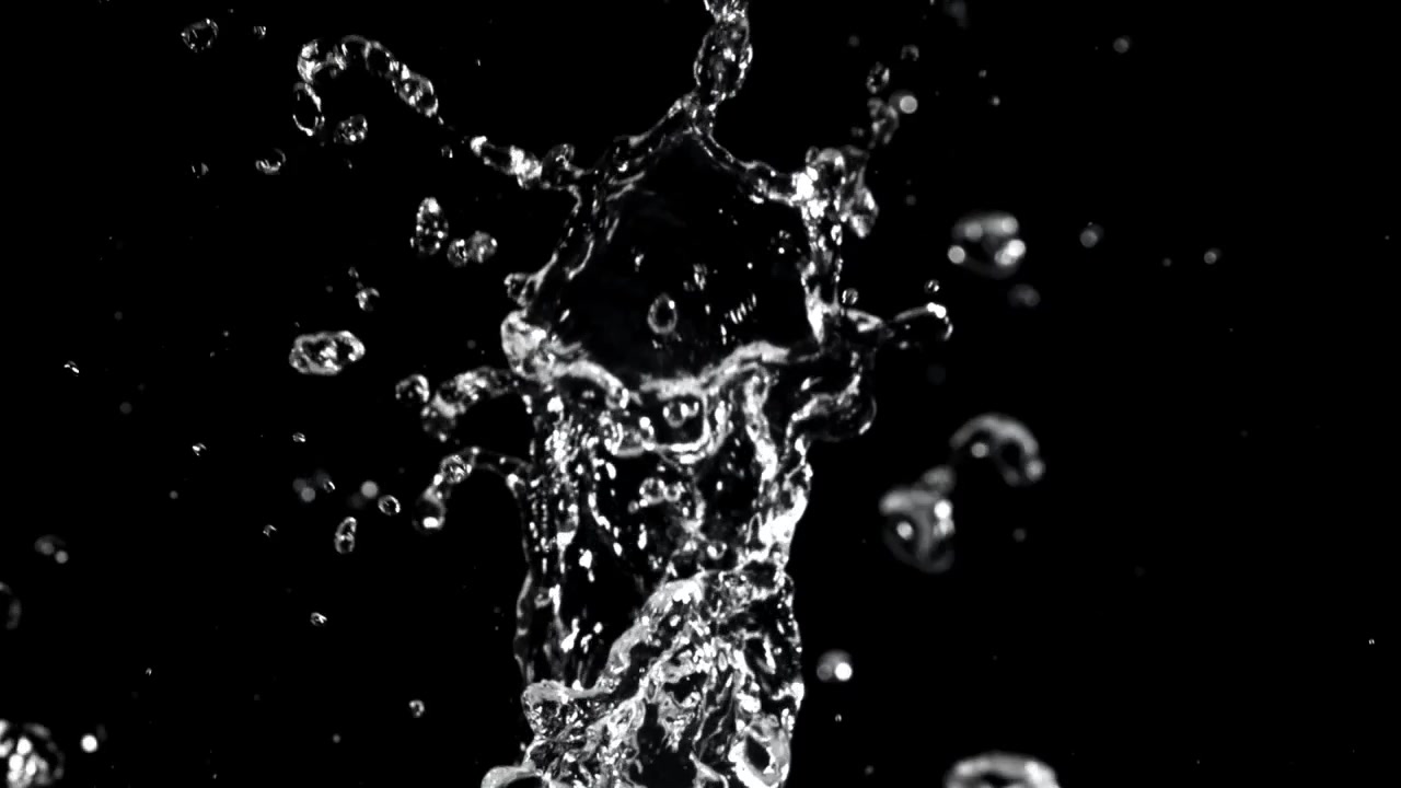 Vandstænk og dråber i slowmotion på sort baggrund