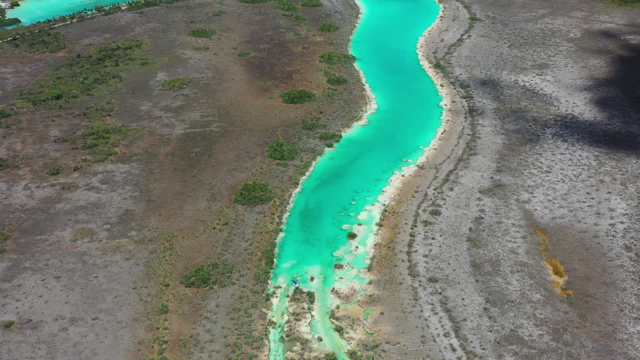 Drönarflygfoto över Bacalar-lagunen, Mexiko, som visar livfullt turkost vatten som slingrar sig genom frodig djungel och våtmarker. Fantastiskt naturlandskap som framhäver den berömda ”Lagunen med de sju färgerna.”