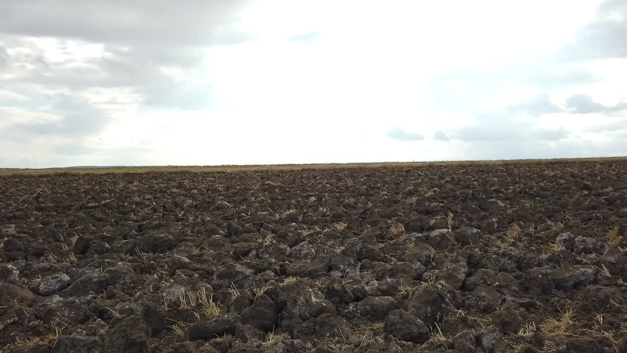 Čerstvě zorané pole a zatažená obloha.