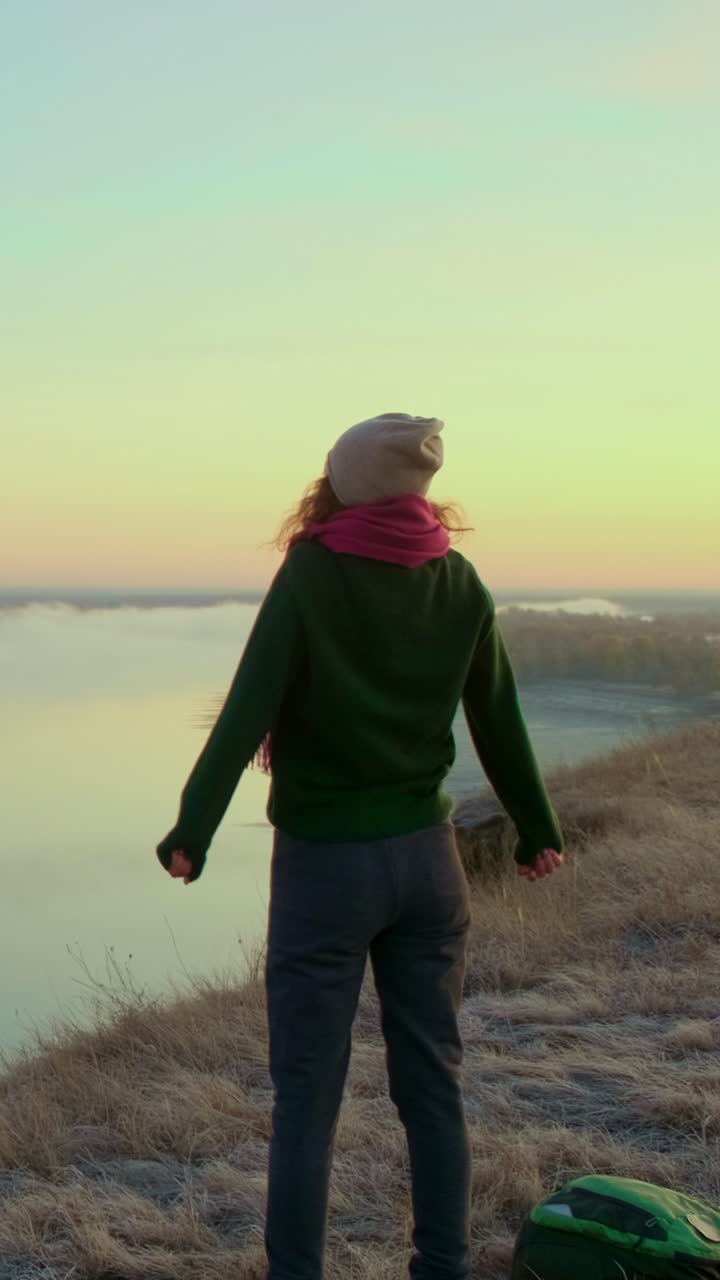 Woman Hiking at Sunrise Over a Misty River