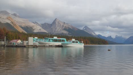 tourism boats docked on stunning glacial water lake surrounded by the canadian rocky mountains