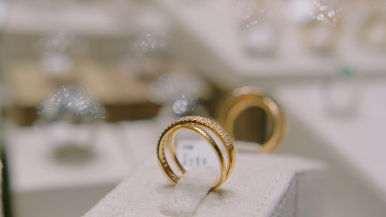 Gold Rings with Precious Stones Rotating in a Shop Window