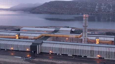 Aerial-shot-of-large-polluting-metal-factory-in-Iceland,-Reyðarfjörður-fjord