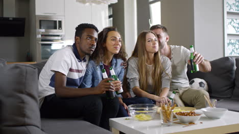 Two-Couples-Sitting-On-The-Couch,-Eating-Snacks-And-Watching-Tv