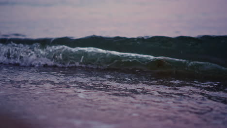 ocean waves splashing sandy beach in slow motion. sea water waving at sand beach