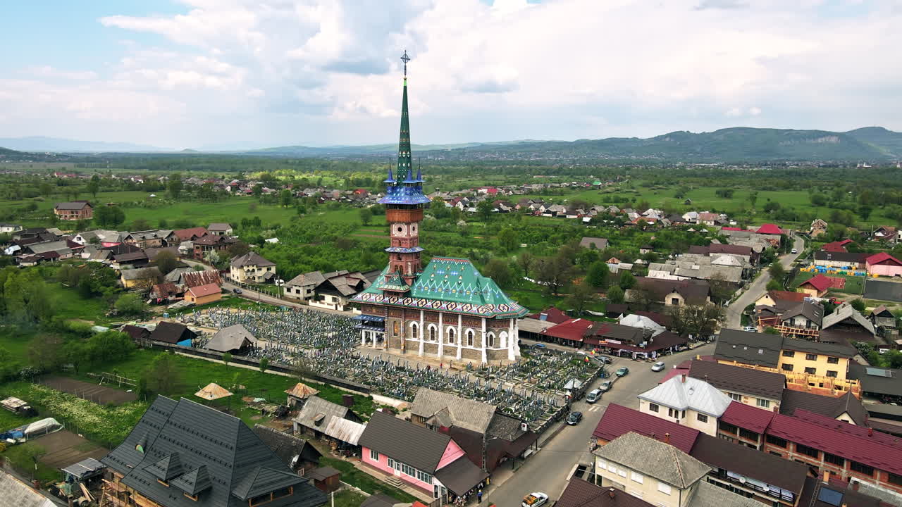 Vista aerea con drone del Cimitero Allegro a Săpânța, Romania. Chiesa e cimitero, edifici residenziali intorno
