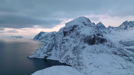 extreme lofoten islands wintry frozen mountain and blue ocean landscape aerial view dolly right