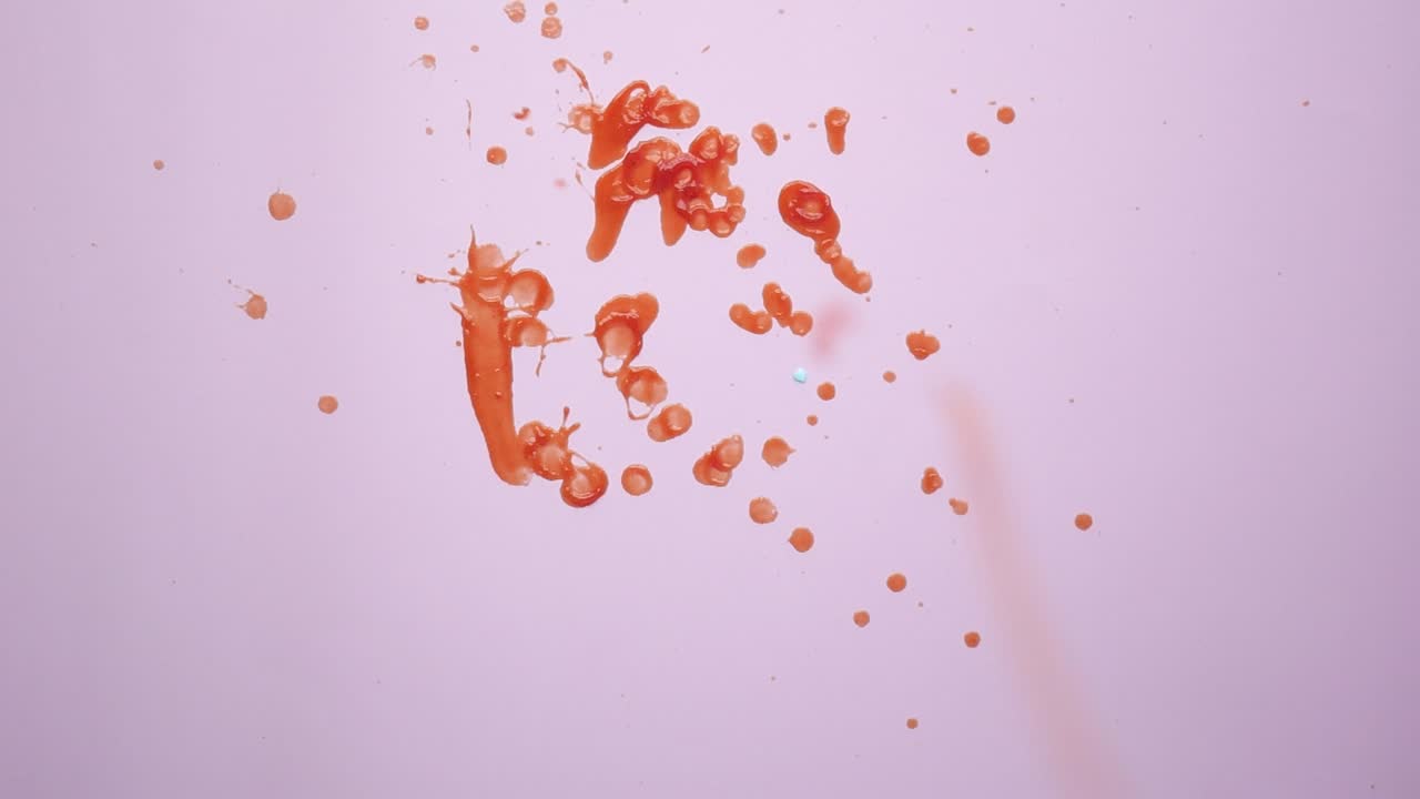 salpicaduras de pintura naranja sobre un fondo rosado