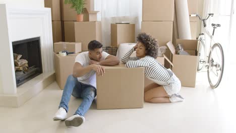 Tired-young-couple-relaxing-on-cardboard-boxes