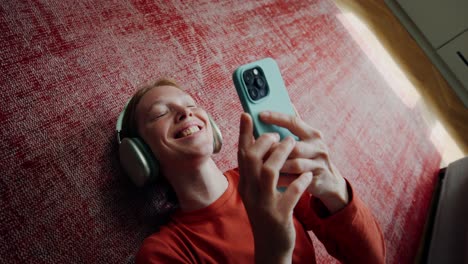 woman relaxing on floor with headphones and phone