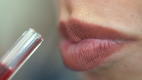 close up of a woman's attractive lips drinking a red juice through a straw - concept: sexual, health, mindful, juicing, volume, voluptuous, lady