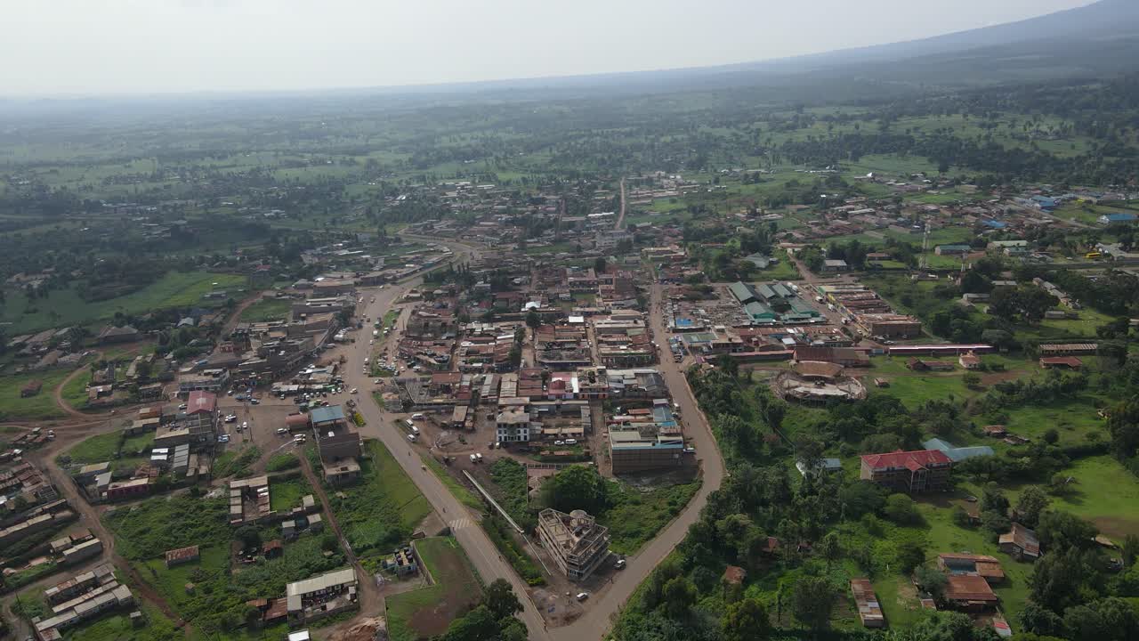 vista panorámica de un paisaje urbano rural con campos verdes y casas en loitokitok, kenia durante el día - toma aérea de drones