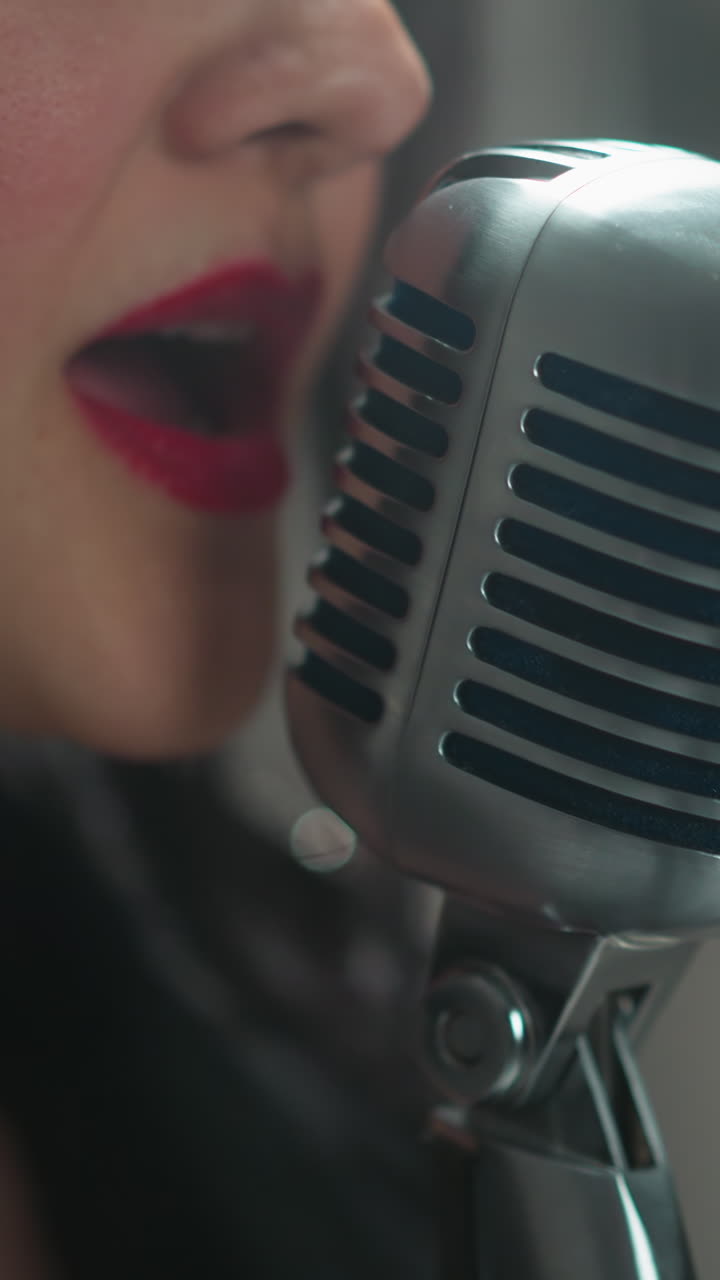 여성 가수 의 입술 과 빈티지 마이크 의 클로즈업, 흐릿 한 배경 에 맞춰 노래 하는 것