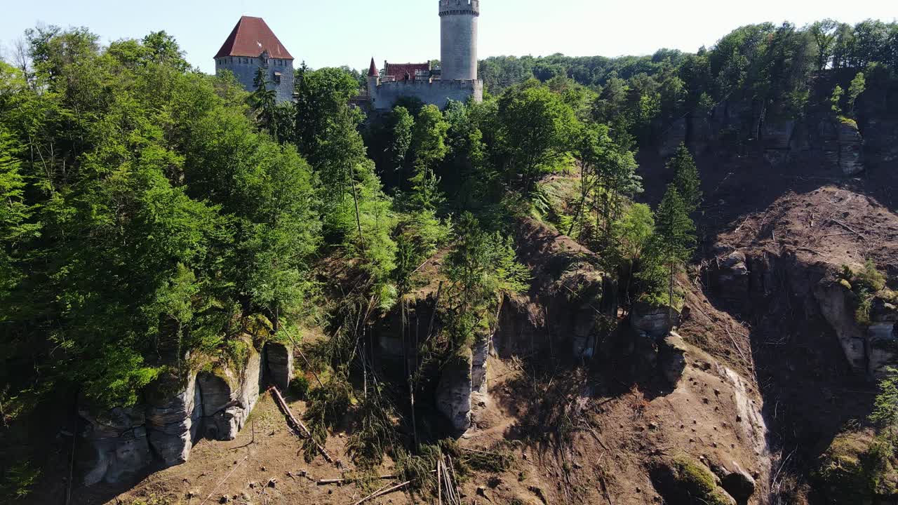 Historic Medieval Kokorin Castle rising above sandstone cliffs, green woodland