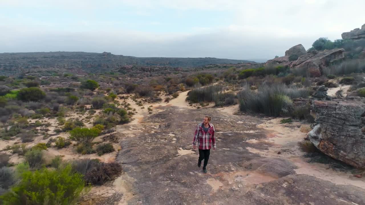 hombre caminando por un sendero rocoso 4k
