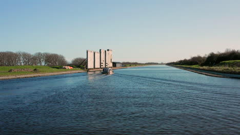 Aerial:-A-yacht-passing-the-locks-near-the-Canal-through-Walcheren,-near-the-historical-town-Veere