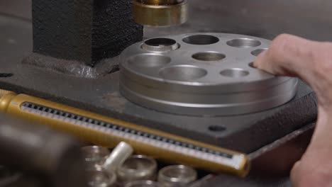 Jeweler making a silver ring using press