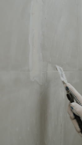 repairing a hole in a wall with a putty knife