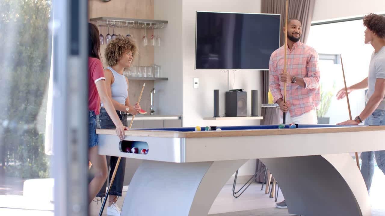 Playing pool, Diverse friends enjoying leisure time together in modern living room