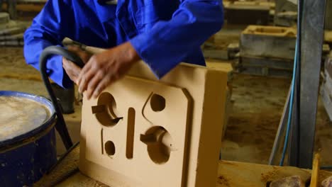 worker inserting pipe in mold 4k