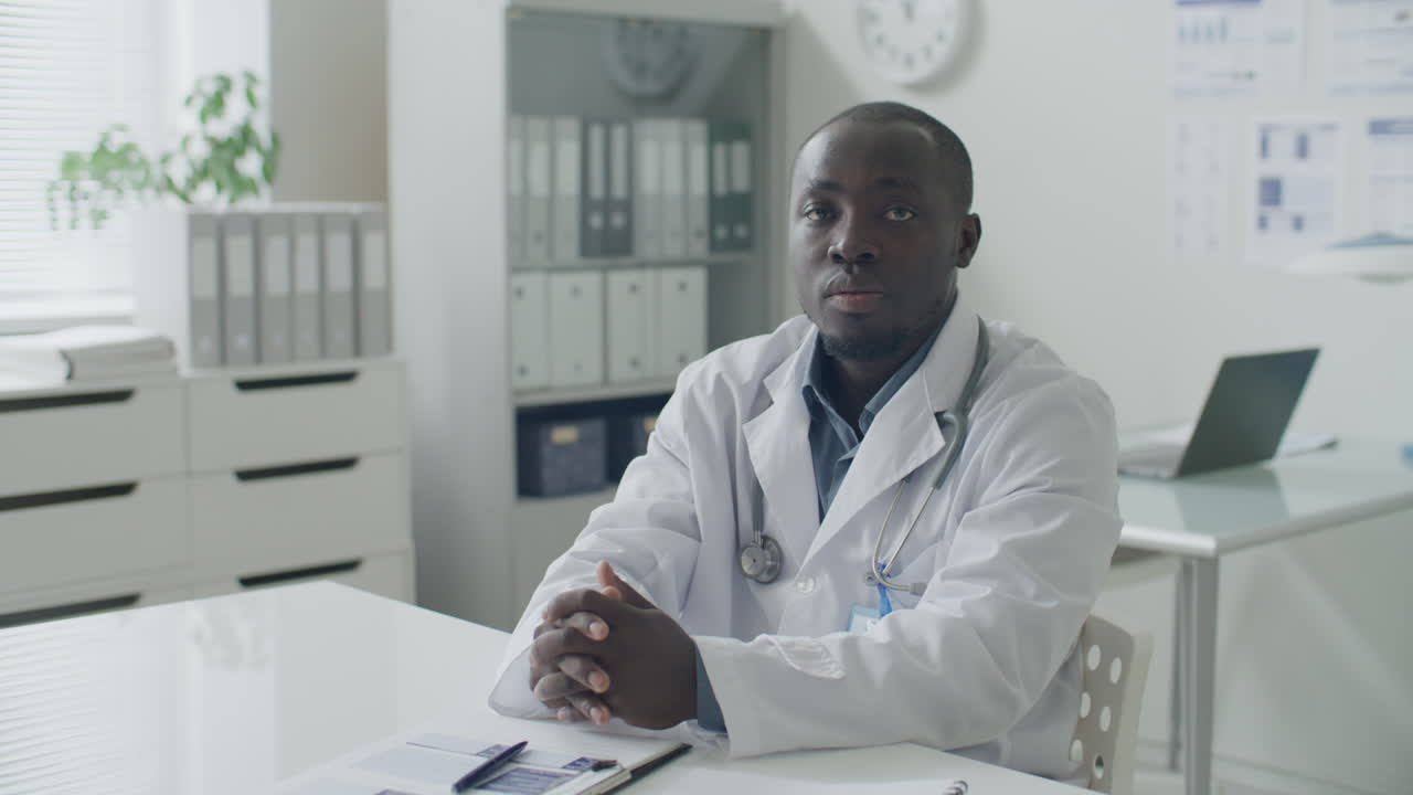 Portrait d'un médecin afro-américain à son bureau dans un cabinet médical