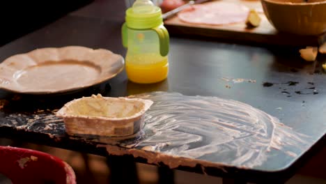 mesa desordenada y trona después de alimentar al bebé en la cocina de casa