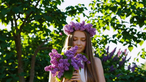young woman enjoying the scent of lilac flowers