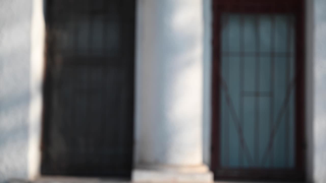 Young man putting black wireless earbud in the ear outdoors