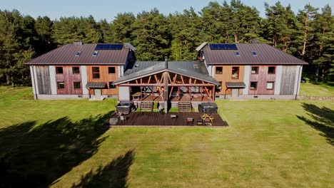aerial reveal of cozy wooden guesthouse nestled in pine forest in rural latvia