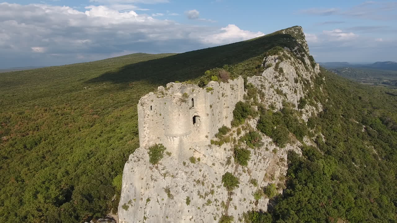 volando alrededor de un castillo en ruinas en el borde de una montaña.